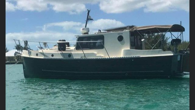 Boat anchored on calm turquoise water under clear skies.